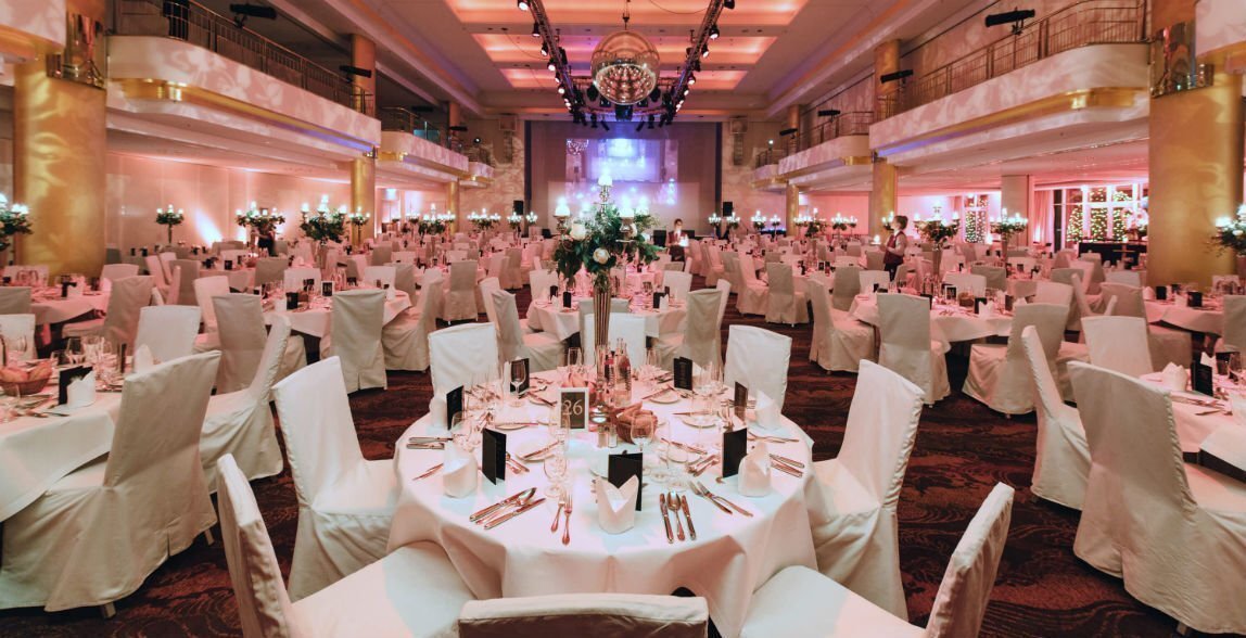 Saal gedeckt für eine Hochzeit ganz in weiß mit Platznummerierungen