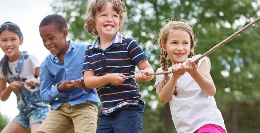 Kinder ziehen gemeinsam an einem Tau