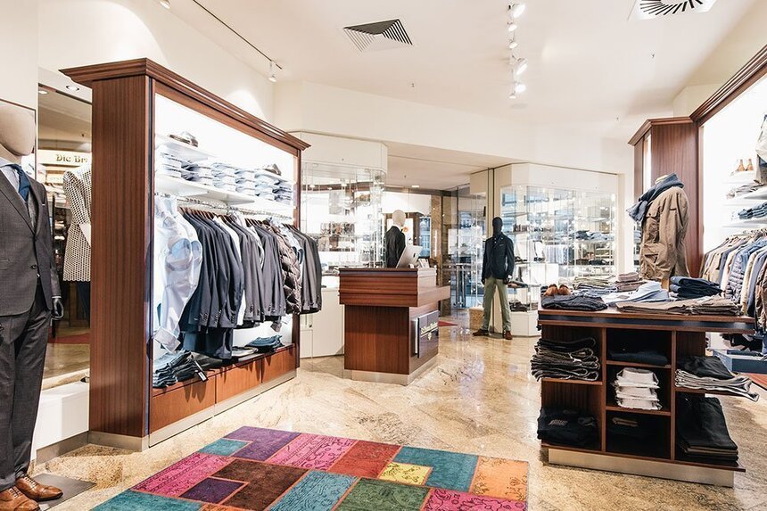 Männerabteilung eines Modegeschäfts mit ausgestellten Anzügen